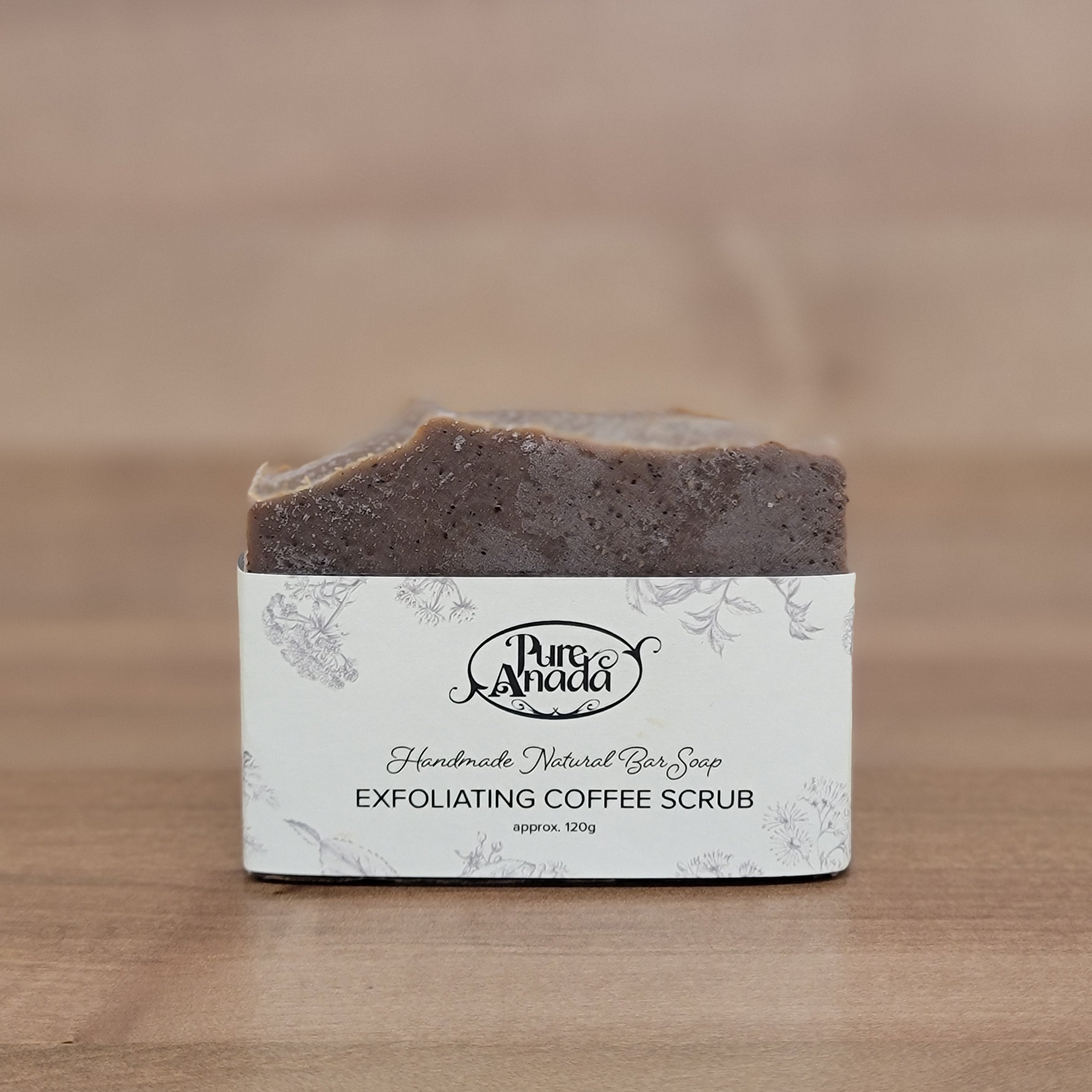 Exfoliating coffee scrub bar with a Pure Anada label on a wooden surface